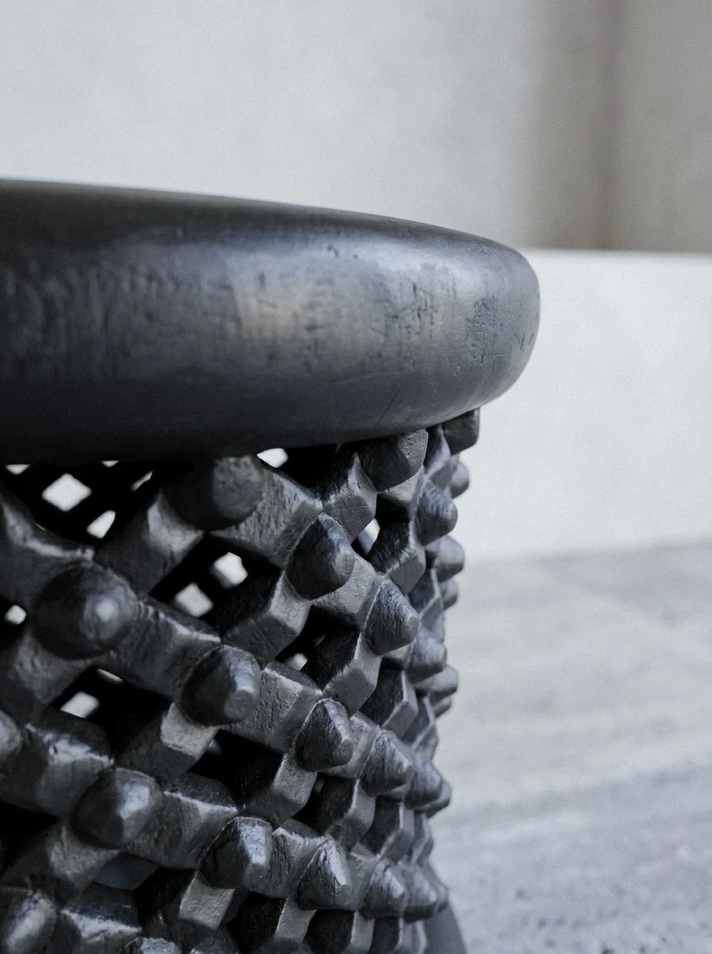 Detail of hand-chiseled nodes and matte ebonized patina on the sculptural stool